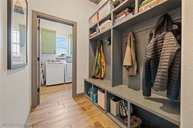 mudroom with baseboards, plenty of natural light, light wood-type flooring, and washer and clothes dryer