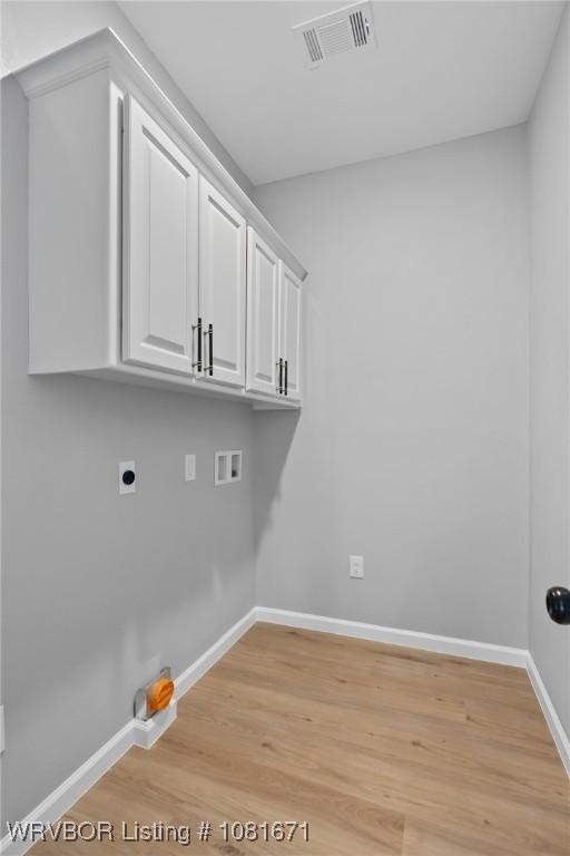 179 E Grove St, Magazine, AR 72943 - laundry room with hookup for a washing machine, light wood-type flooring, hookup for an electric dryer, and cabinet space