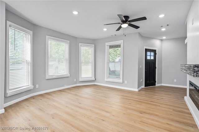 179 E Grove St, Magazine, AR 72943 - unfurnished living room with light wood finished floors, a ceiling fan, a glass covered fireplace, and recessed lighting