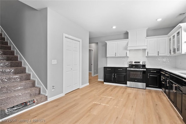 179 E Grove St, Magazine, AR 72943 - kitchen with electric stove, white cabinets, dark cabinets, light wood-style floors, and recessed lighting