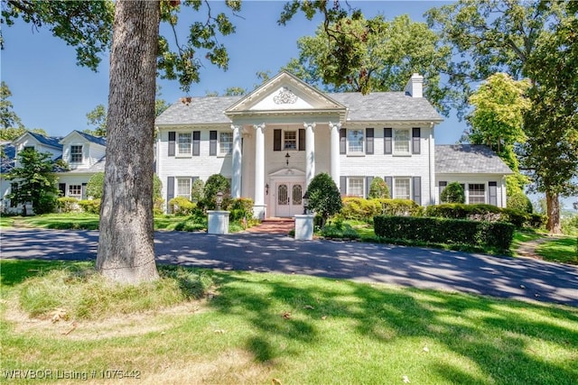 greek revival inspired property with a front lawn