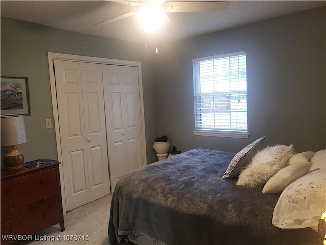 bedroom featuring light carpet, ceiling fan, and a closet