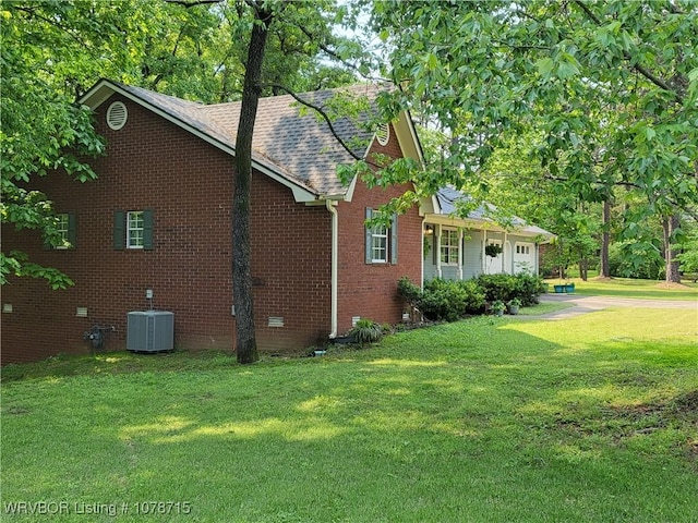 view of home's exterior featuring central AC unit and a lawn