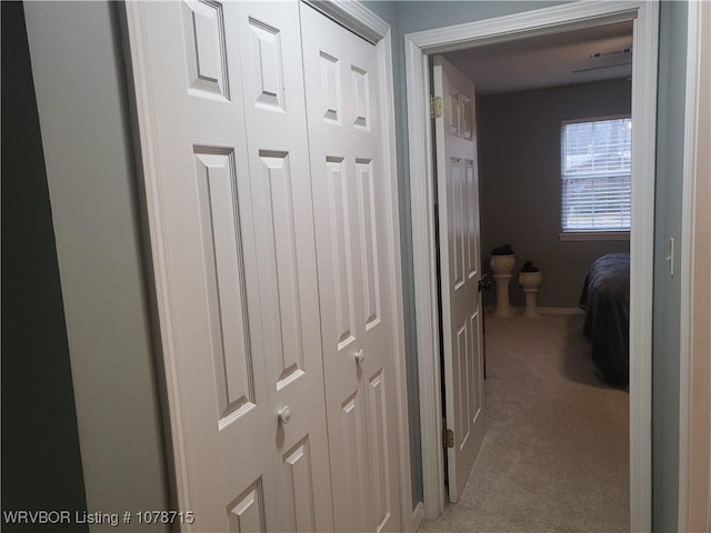 hallway featuring light colored carpet