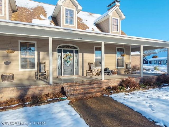 cape cod-style house featuring covered porch