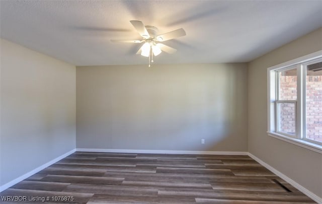 spare room with ceiling fan, dark wood-type flooring, and a wealth of natural light