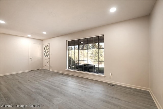 empty room featuring recessed lighting, baseboards, and wood finished floors