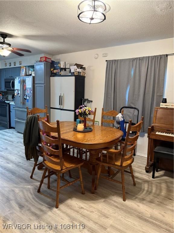 2303 Willow St, Van Buren, AR 72956 - dining space featuring light wood-style floors, a textured ceiling, and ceiling fan