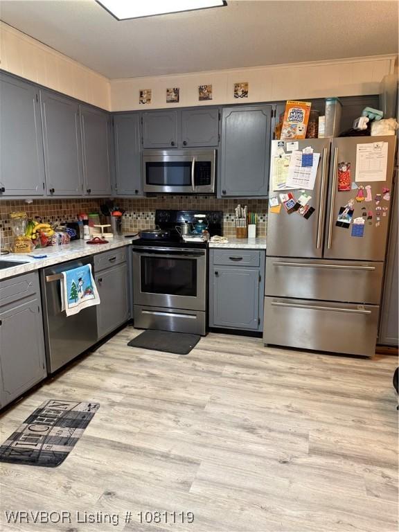2303 Willow St, Van Buren, AR 72956 - kitchen featuring stainless steel appliances, gray cabinetry, light wood-style flooring, and light countertops