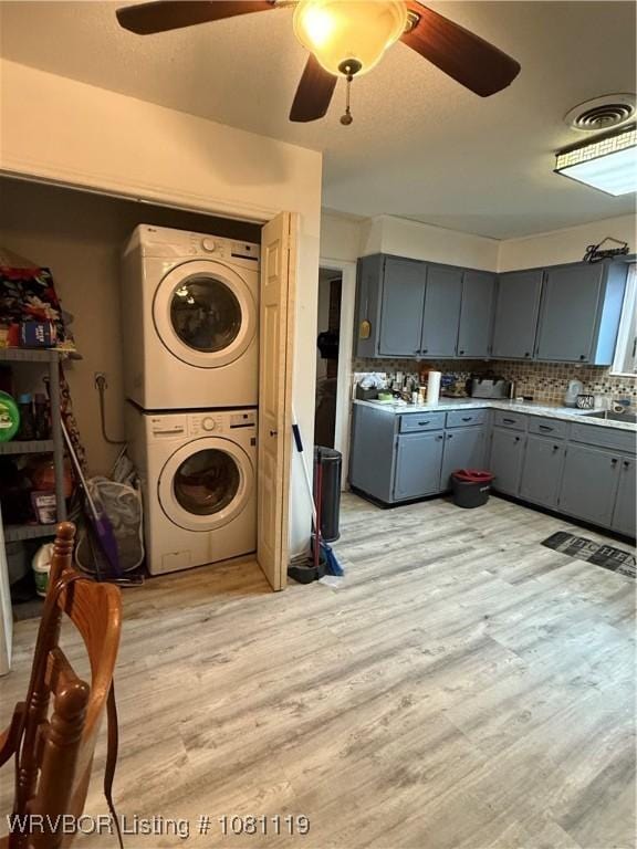 2303 Willow St, Van Buren, AR 72956 - washroom featuring estacked washer and dryer, ceiling fan, and light wood-style flooring