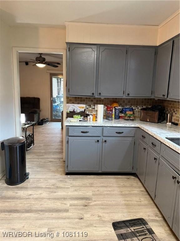 2303 Willow St, Van Buren, AR 72956 - kitchen featuring gray cabinets, ceiling fan, decorative backsplash, light wood-style flooring, and light countertops