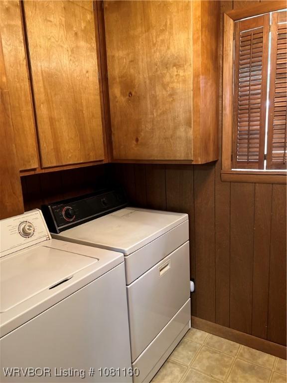 105 7th St, Paris, AR 72855 - washroom with washer and clothes dryer, cabinet space, and wooden walls