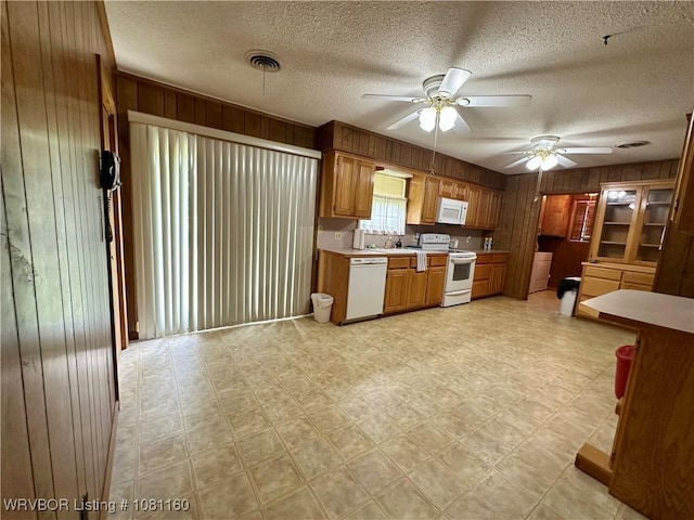 105 7th St, Paris, AR 72855 - kitchen with white appliances, wood walls, ceiling fan, light countertops, and a textured ceiling