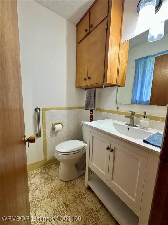 105 7th St, Paris, AR 72855 - half bathroom featuring wainscoting, vanity, tile patterned floors, and tile walls