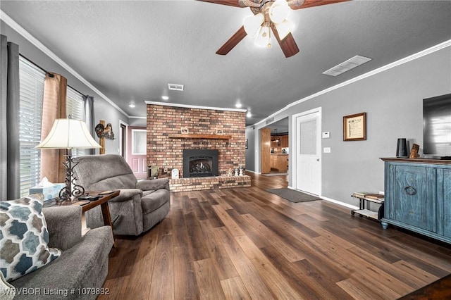 living room featuring a textured ceiling, visible vents, wood finished floors, and a ceiling fan