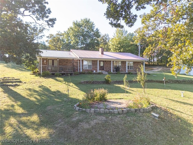 view of front of home featuring a front lawn, a chimney, a porch, and brick siding