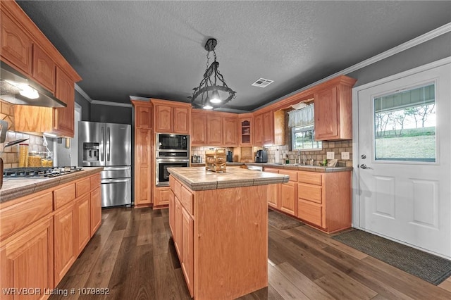 kitchen with dark wood-style flooring, tile countertops, visible vents, and appliances with stainless steel finishes