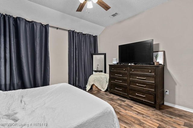 bedroom featuring ceiling fan, dark hardwood / wood-style flooring, a textured ceiling, and vaulted ceiling