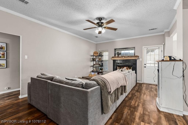 living room featuring ceiling fan, dark hardwood / wood-style flooring, ornamental molding, and a textured ceiling