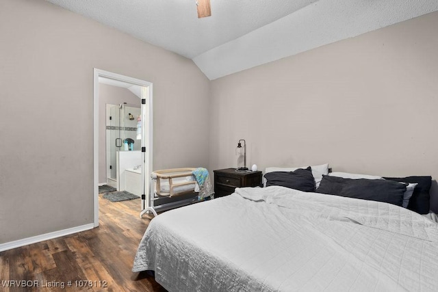 bedroom with ceiling fan, ensuite bathroom, lofted ceiling, and dark wood-type flooring