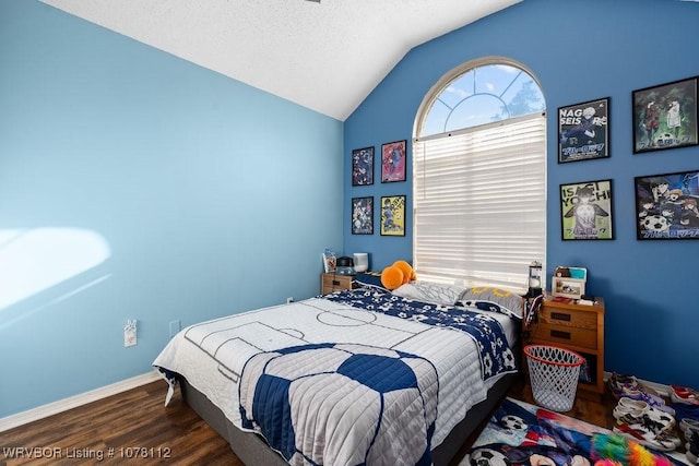 bedroom featuring a textured ceiling, vaulted ceiling, and dark wood-type flooring