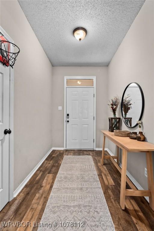 entrance foyer with a textured ceiling and dark wood-type flooring