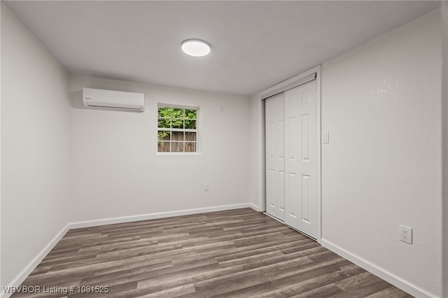 2308 N 50th St, Fort Smith, AR 72904 - unfurnished bedroom featuring a wall unit AC, dark wood finished floors, baseboards, and a closet