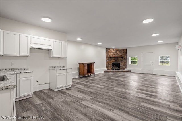 2308 N 50th St, Fort Smith, AR 72904 - kitchen with white cabinetry, under cabinet range hood, dark wood-type flooring, open floor plan, and light stone countertops