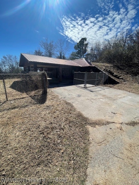 exterior space featuring metal roof, a carport, and driveway