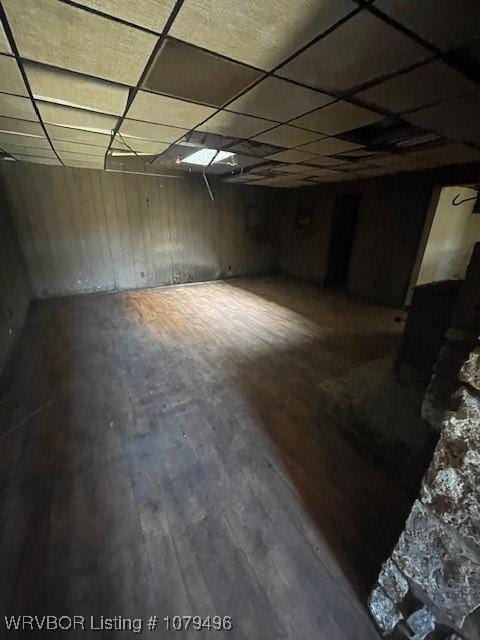 basement featuring a paneled ceiling and wood finished floors