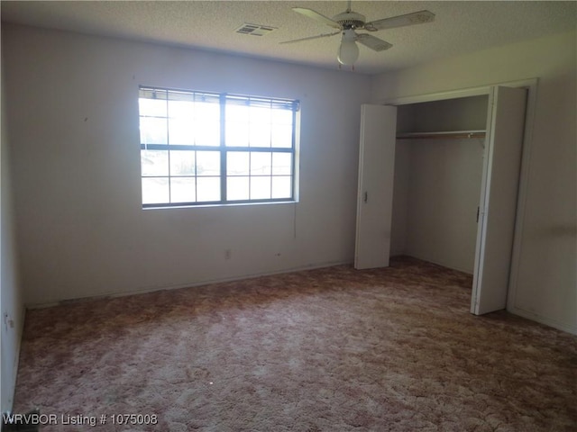 unfurnished bedroom featuring carpet flooring, ceiling fan, and a textured ceiling