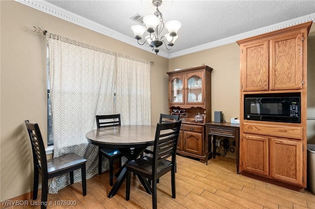 dining area with a notable chandelier, ornamental molding, a textured ceiling, and light hardwood / wood-style flooring