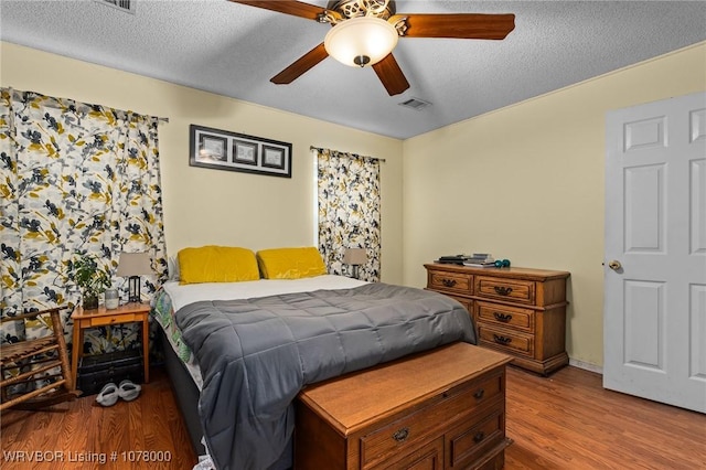 bedroom with wood-type flooring, a textured ceiling, and ceiling fan