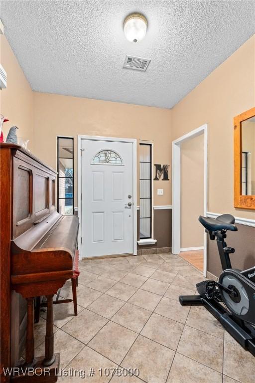 foyer with light tile patterned flooring and a textured ceiling