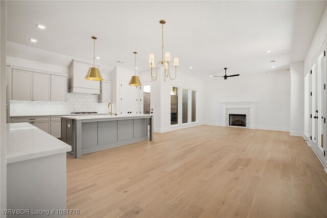 7627 Woodbine Ln, Fort Smith, AR 72916 - kitchen featuring backsplash, a chandelier, light wood-style floors, recessed lighting, and custom exhaust hood