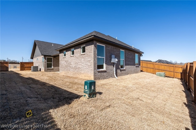 7627 Woodbine Ln, Fort Smith, AR 72916 - back of property featuring brick siding, a fenced backyard, and roof with shingles