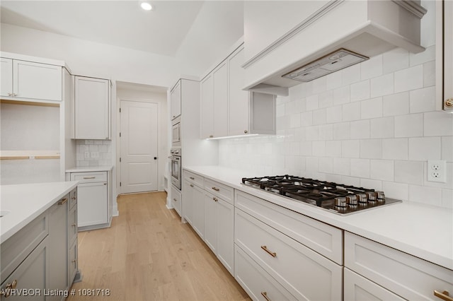 7627 Woodbine Ln, Fort Smith, AR 72916 - kitchen featuring appliances with stainless steel finishes, decorative backsplash, light countertops, light wood-style floors, and recessed lighting