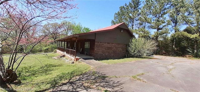 710 E 4th St, Hartford, AR 72938 - view of home's exterior featuring a yard, brick siding, and a porch
