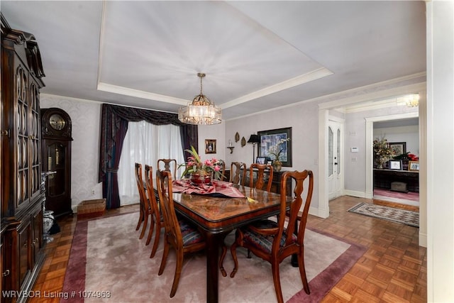 dining room featuring dark parquet floors, a raised ceiling, and a chandelier