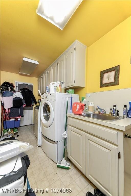 clothes washing area with cabinets and sink