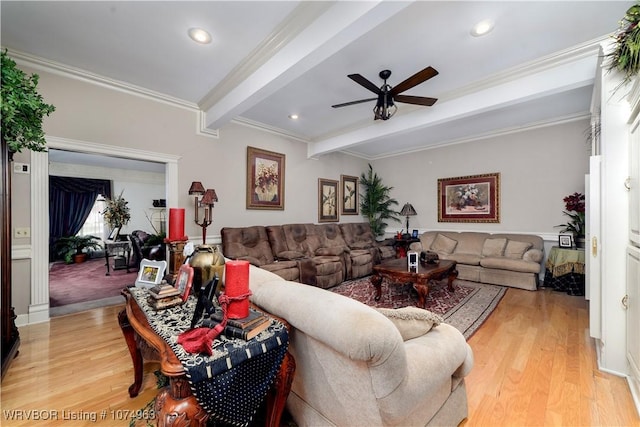 living room with light hardwood / wood-style floors, ceiling fan, beam ceiling, and ornamental molding