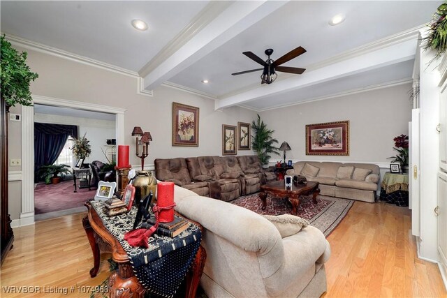 living room with light hardwood / wood-style floors, ceiling fan, beam ceiling, and ornamental molding