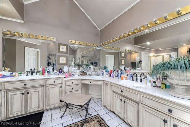 bathroom with tile patterned floors, vanity, ornamental molding, and vaulted ceiling