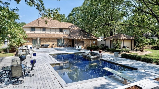 view of swimming pool with a diving board, a patio, and a deck