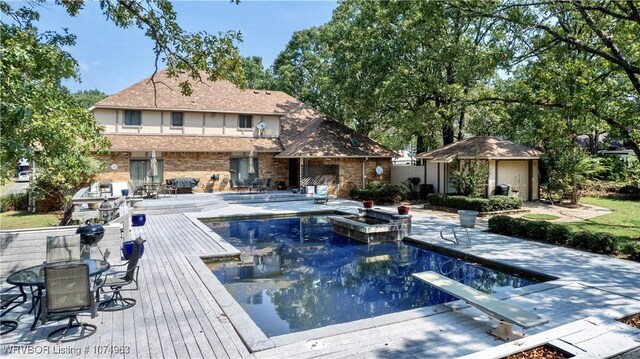 view of swimming pool with a diving board, a patio, and a deck