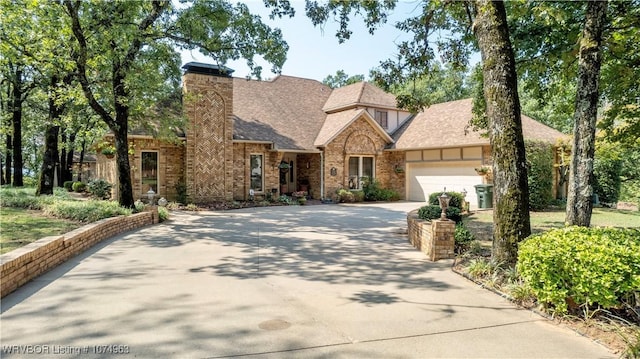 english style home featuring a garage