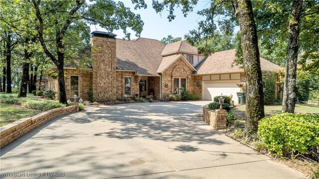 english style home featuring a garage