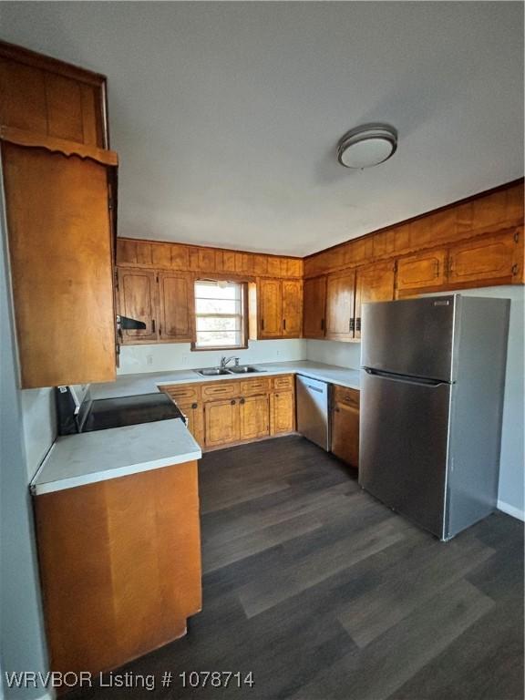 kitchen featuring sink, stainless steel appliances, dark hardwood / wood-style floors, and extractor fan