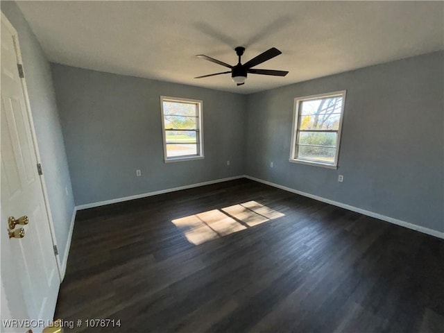 spare room featuring ceiling fan, a healthy amount of sunlight, and dark hardwood / wood-style floors