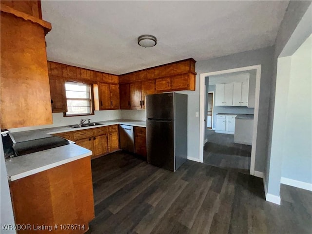 kitchen with sink, black fridge, stainless steel dishwasher, dark hardwood / wood-style floors, and stove